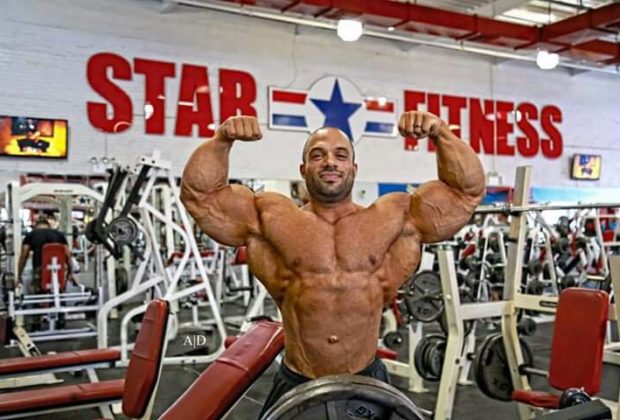 john dela rosa esegue la posa di doppi bicipiti frontali in palestra