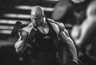 MIKA SIHVONEN IFBB ELITE PRO allena i bicipiti con il curl con i manubri
