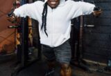 kai greene in palestra allena i pettorali con i cavi alti
