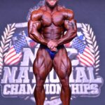 Jonathan Withers esegue la posa di most muscular sul palco dei nationals npc 2020