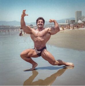 samir bannout in una posa classica in spiaggia