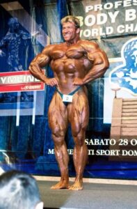Gunter Schlierkamp pro ifbb esegue la posa di apertura dorsali sul palco di una gara a San Marino nel 2000