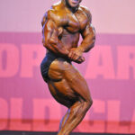Ahmad Ashkanani posa di side chest sul palco della categoria men's bodybuilding fino a 85 kg all’Arnold Classic Europe Amateur 2013